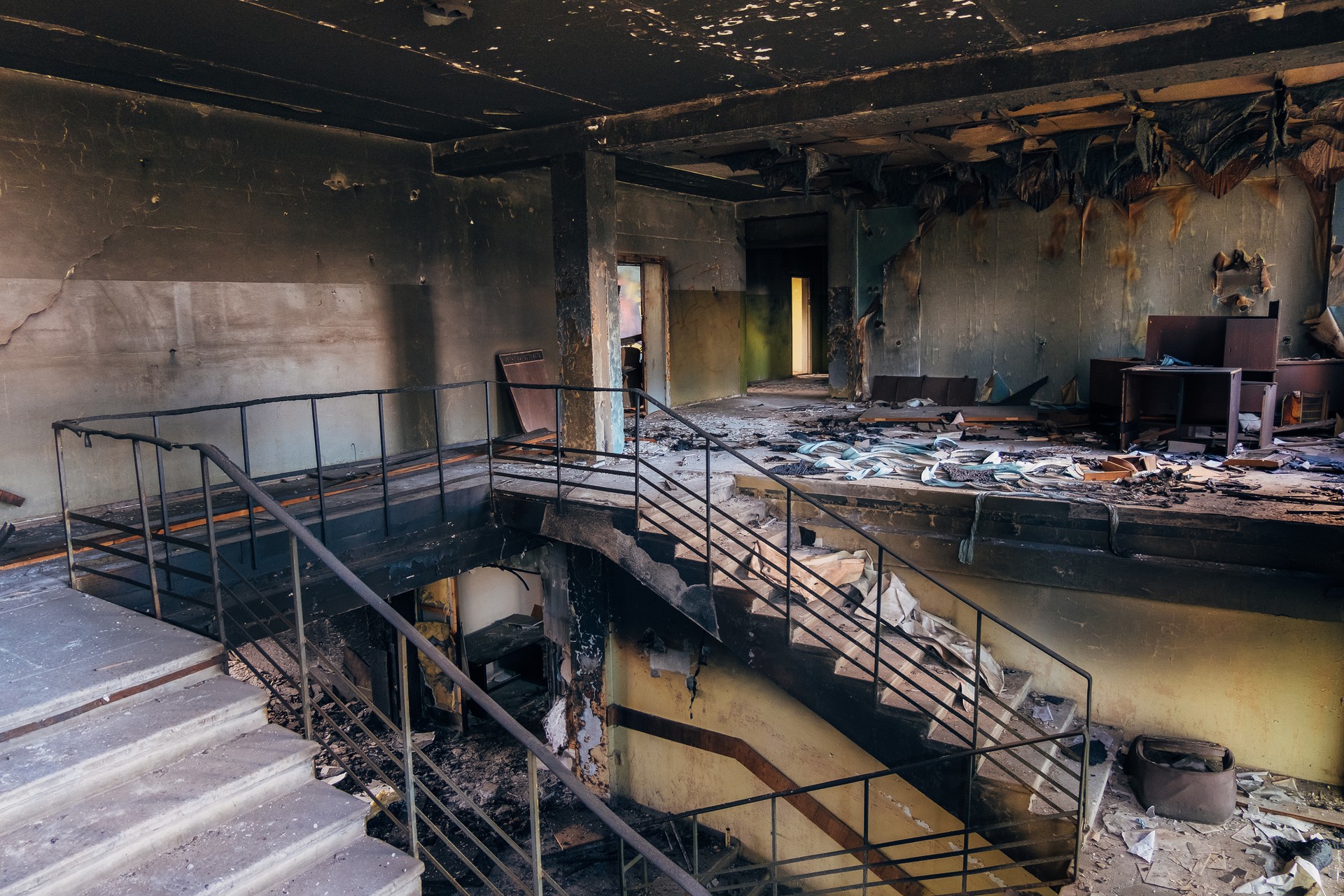 Burned interiors after fire in industrial or office building. Walls and staircase in black soot